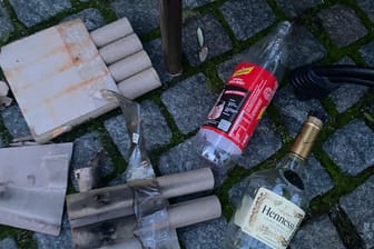 Silvestermüll sowie eine Schweppes- und eine Kognak-Flasche liegen auf der Terrasse des Restaurants "Mühlenstein".