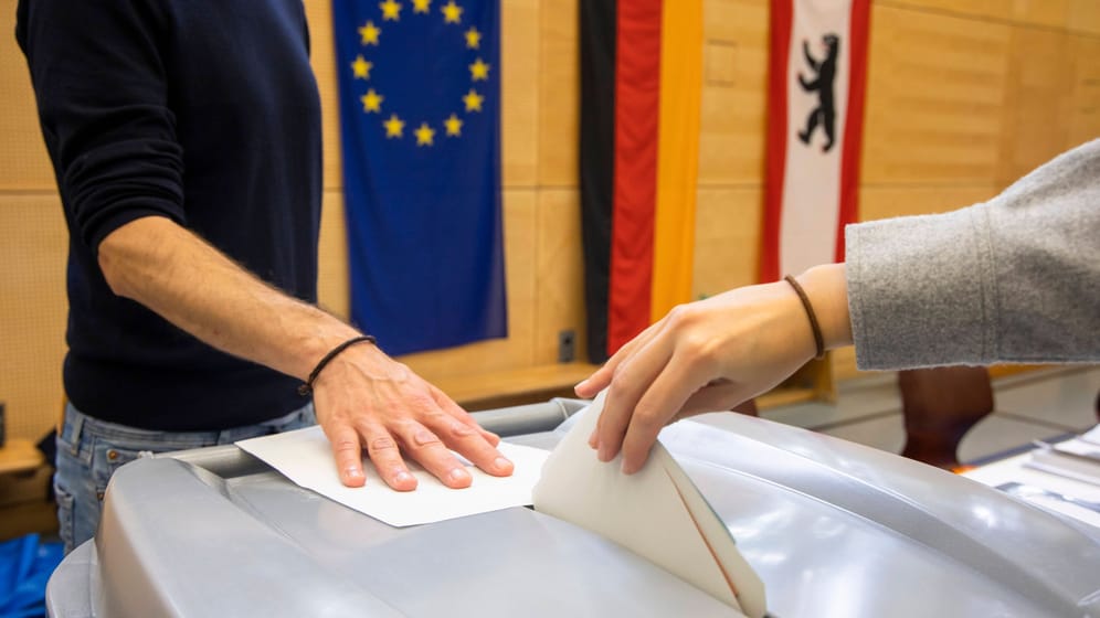 Eine Person wirft einen Stimmzettel in ein Box (Archivbild): Wie geht es nun mit der Berlin-Wahl weiter?