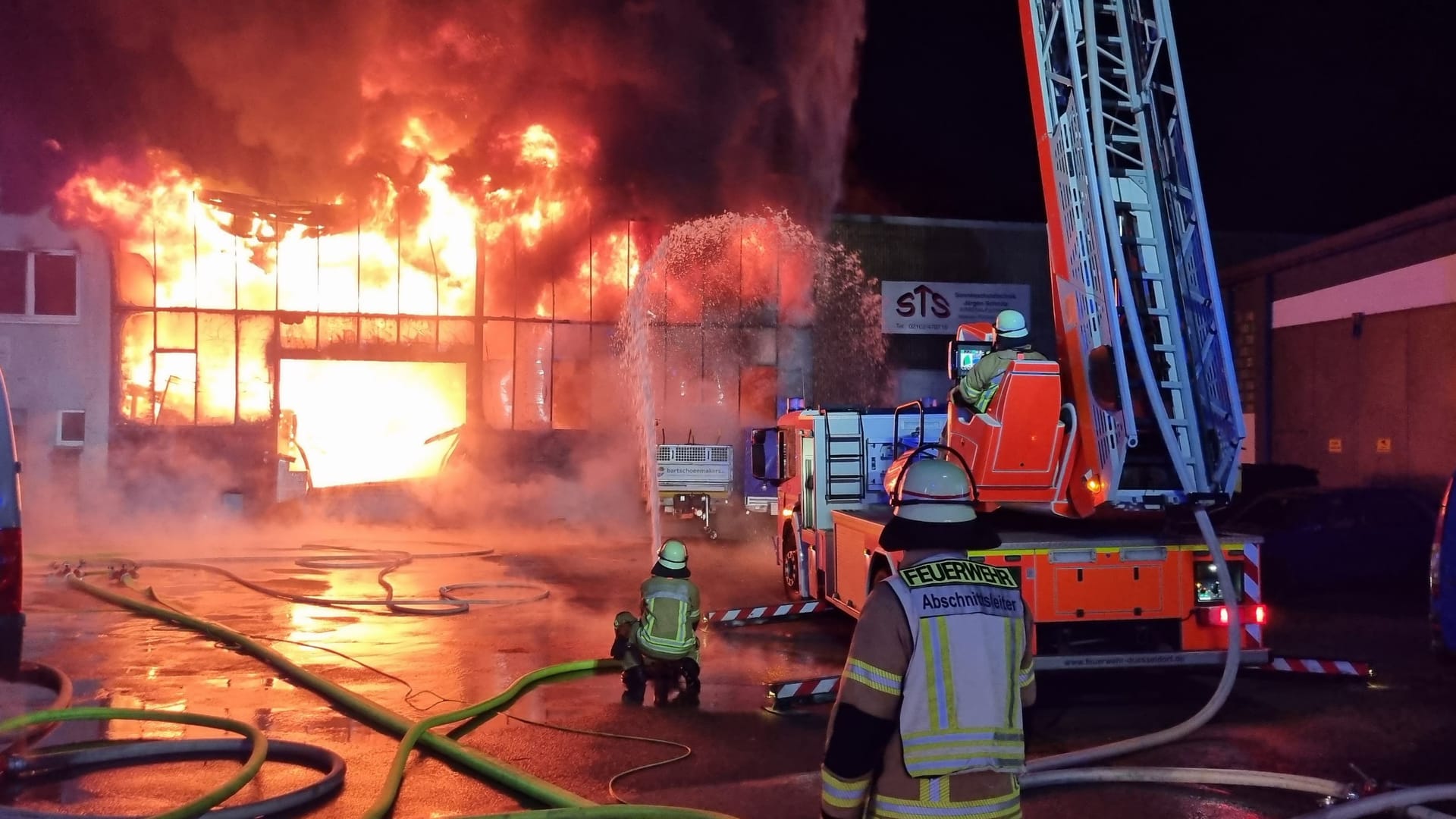 Der Gewerbebetrieb in Flammen: Die Feuerwehr versucht ein Übergreifen der Flammen auf Nachbargebäude zu verhindern. Der Gewerbebetrieb in Flammen: Die Feuerwehr versucht ein Übergreifen der Flammen auf Nachbargebäude zu verhindern.