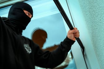 Einbrecher versucht ein Fenster aufzuhebeln (Symbolbild): Die Täter waren zuvor an der Wohnungstüre gescheitert.