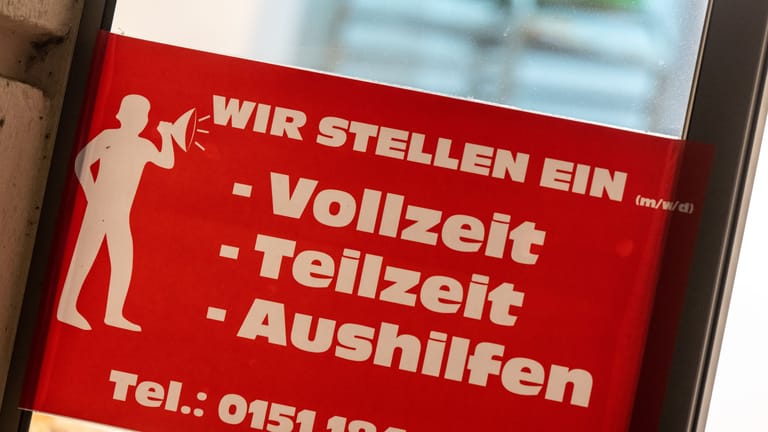 Ein rotes Schild mit der Aufschrift "Wir stellen ein" (Symbolbild): In Deutschland macht sich der Fachkräftemangel zunehmend bemerkbar.