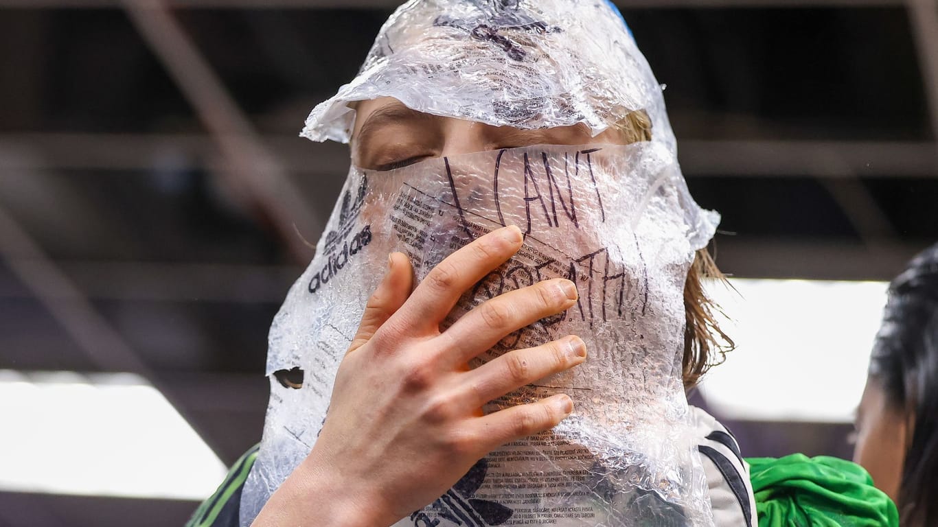 Fashion-Week-Protest: "Can't breathe" steht auf der Folie, die eine Aktivistin um den Kopf gewickelt hat.