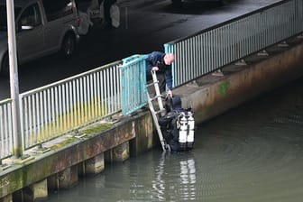 Ein Taucher übergibt ein Fundstück aus dem Ernst-August-Kanal der Spurensicherung (Archivbild): Mitte Januar fischte ein Angler hier Leichenteile aus dem Wasser.
