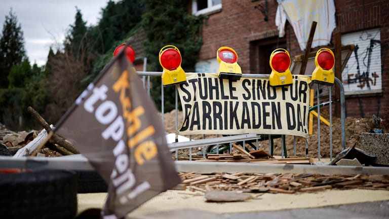 Barrikade vor den Gehöften von Lützerath: Das RWE-Grundstück wird hartnäckig von Kohlegegnerinnen und -gegnern besetzt, die dort unter anderem Baumhäuser gebaut haben, um für den Kohleausstieg zu protestieren.