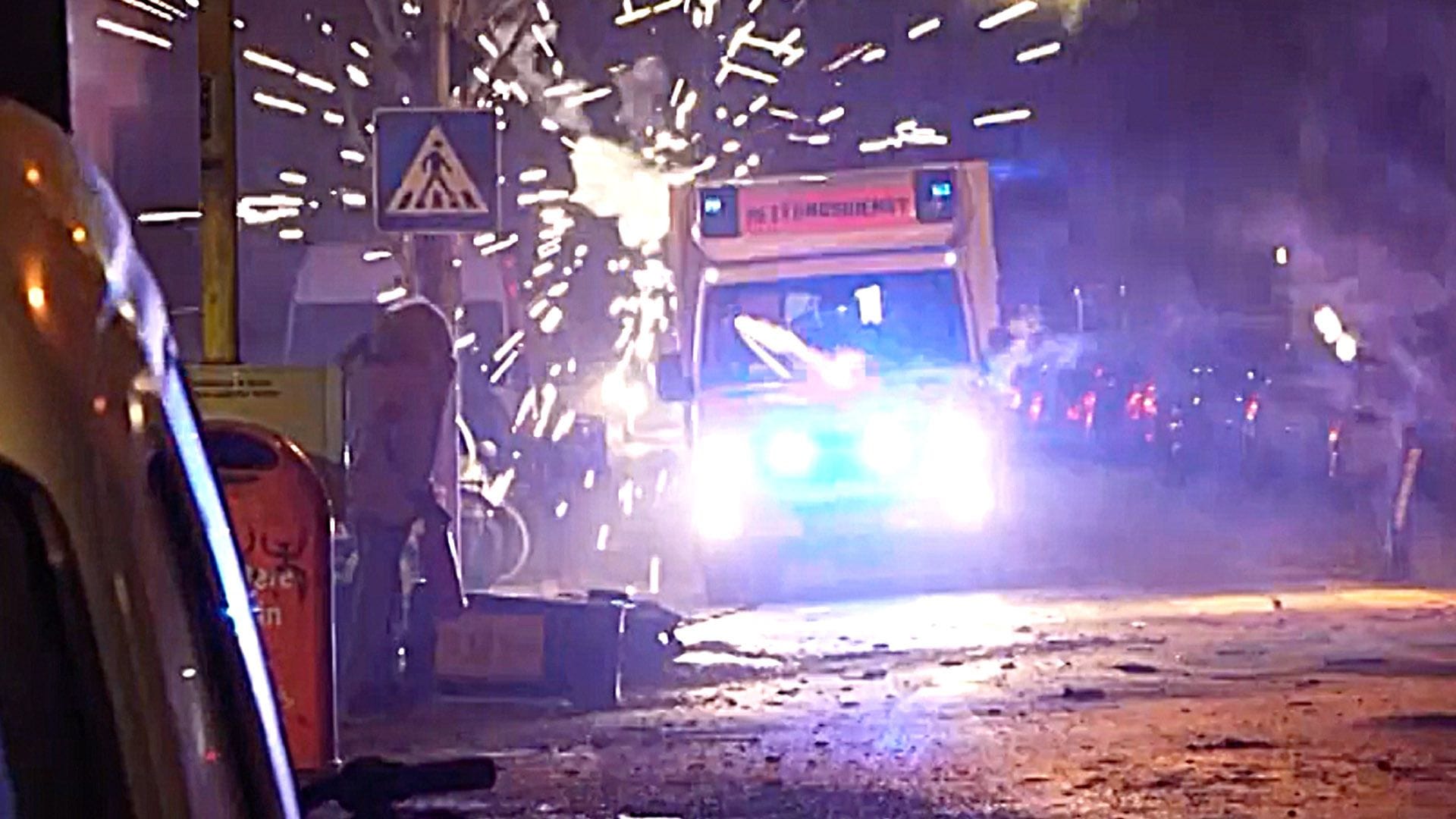 Ein Krankenwagen wird in der Silvesternacht in Berlin von Jugendlichen attackiert.