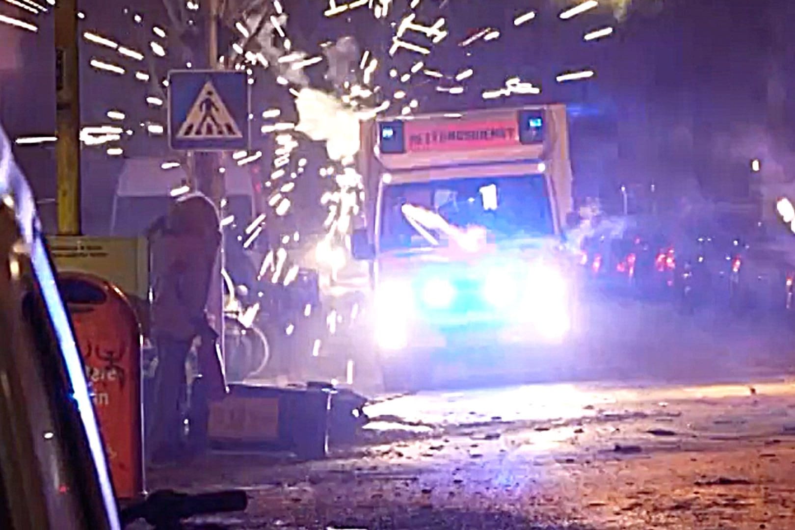 Ein Krankenwagen wird in der Silvesternacht in Berlin von Jugendlichen attackiert.