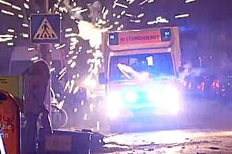 Ein Krankenwagen wird in der Silvesternacht in Berlin von Jugendlichen attackiert.