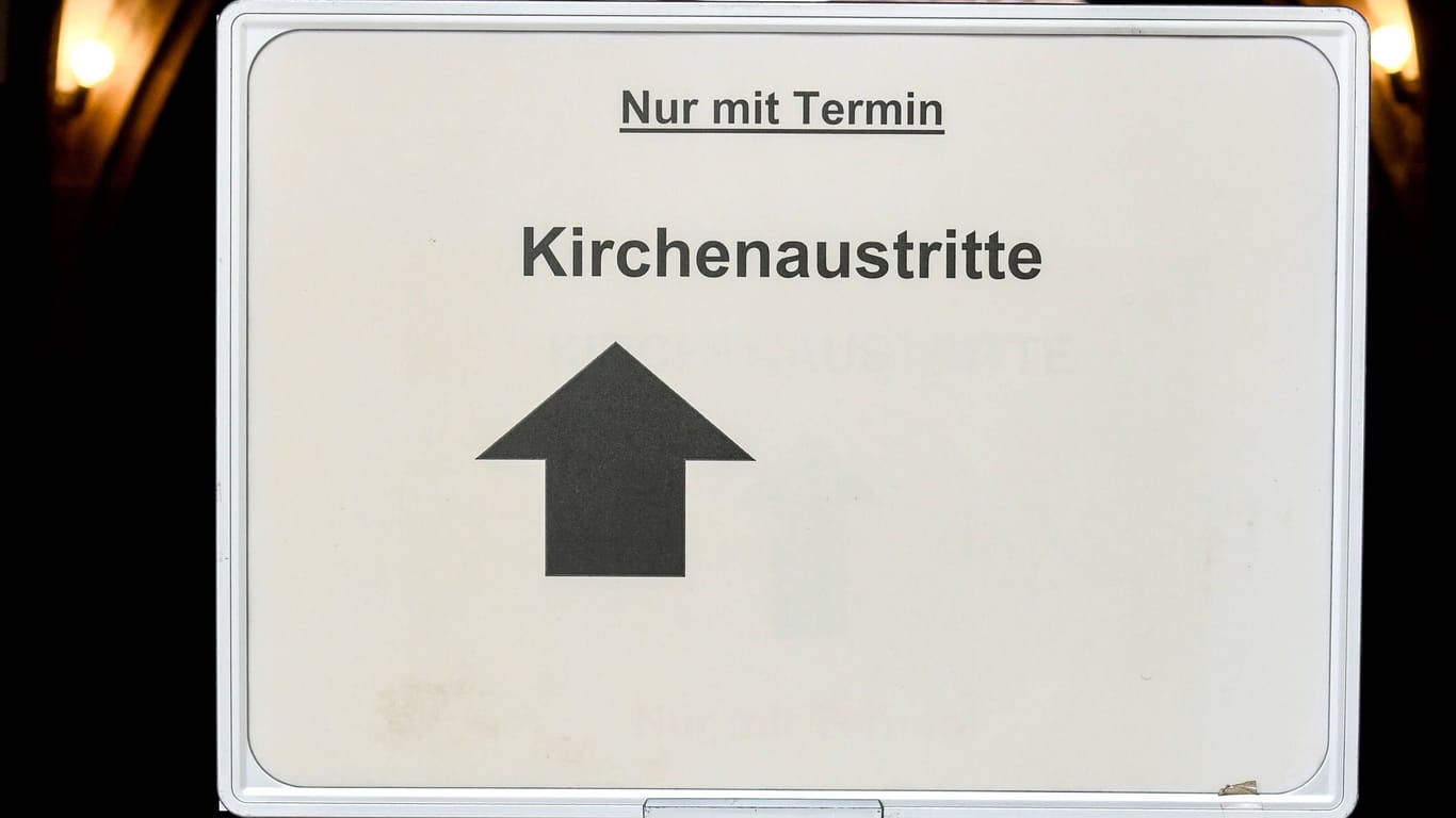Ein Schild mit dem Hinweis "Kirchenaustritte" (Symbolbild): In Köln müssen Bürger im Durchschnitt zwei Monate auf einen Termin zum Kirchenaustritt warten.