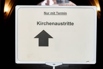 Ein Schild mit dem Hinweis "Kirchenaustritte" (Symbolbild): In Köln müssen Bürger im Durchschnitt zwei Monate auf einen Termin zum Kirchenaustritt warten.