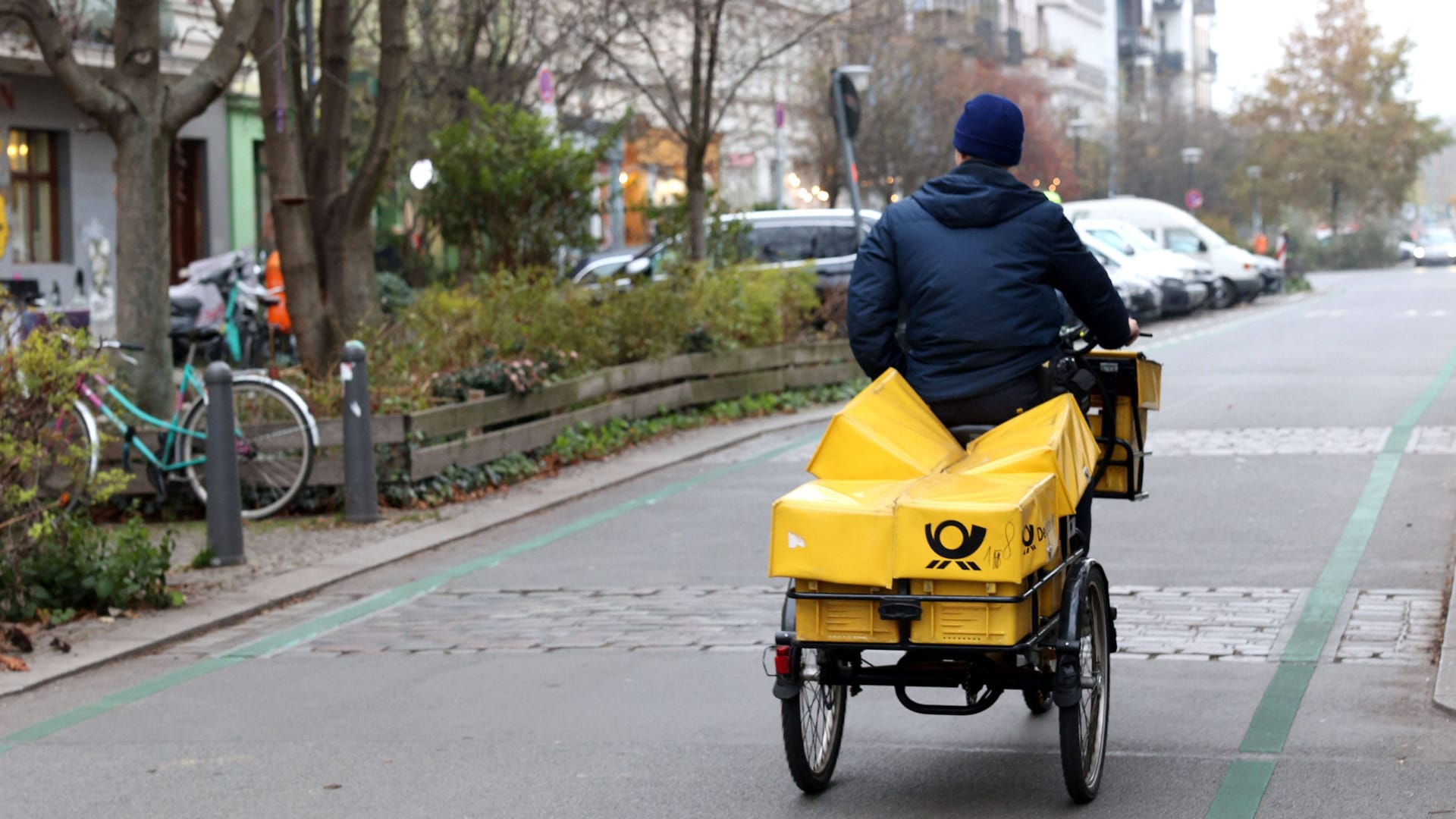 Postbote unterwegs auf dem Rad (Archivbild): In Berlin werden viele Pakete und Briefe zunächst nicht zugestellt.