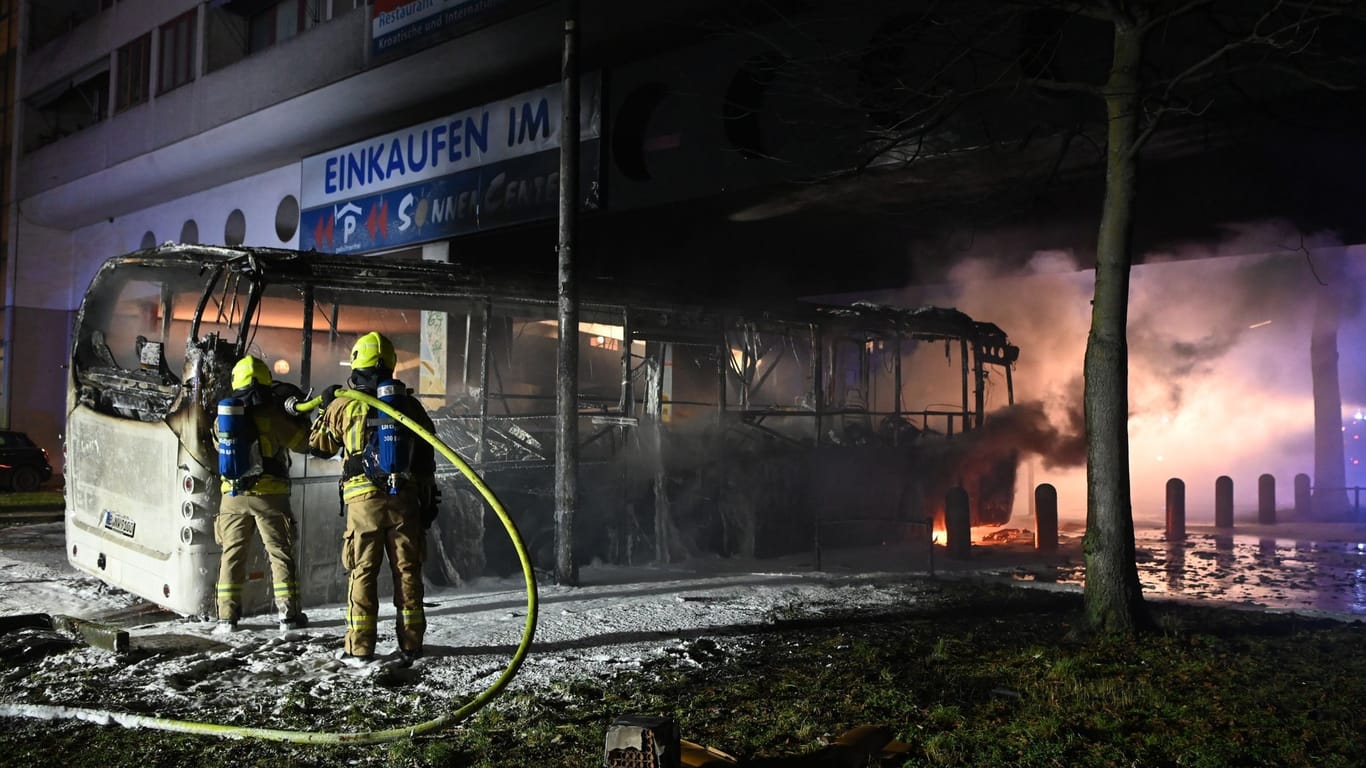 Feuerwehrmänner löschen an der Berliner Sonnenallee einen Reisebus, der in der Silvesternacht von Unbekannten angezündet wurde.