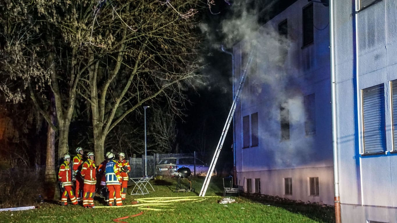 Feuerwehrleute stehen vor der Sozial- und Flüchtlingsunterkunft in Leonberg: 250.000 Euro Schaden sind durch den Brand entstanden.