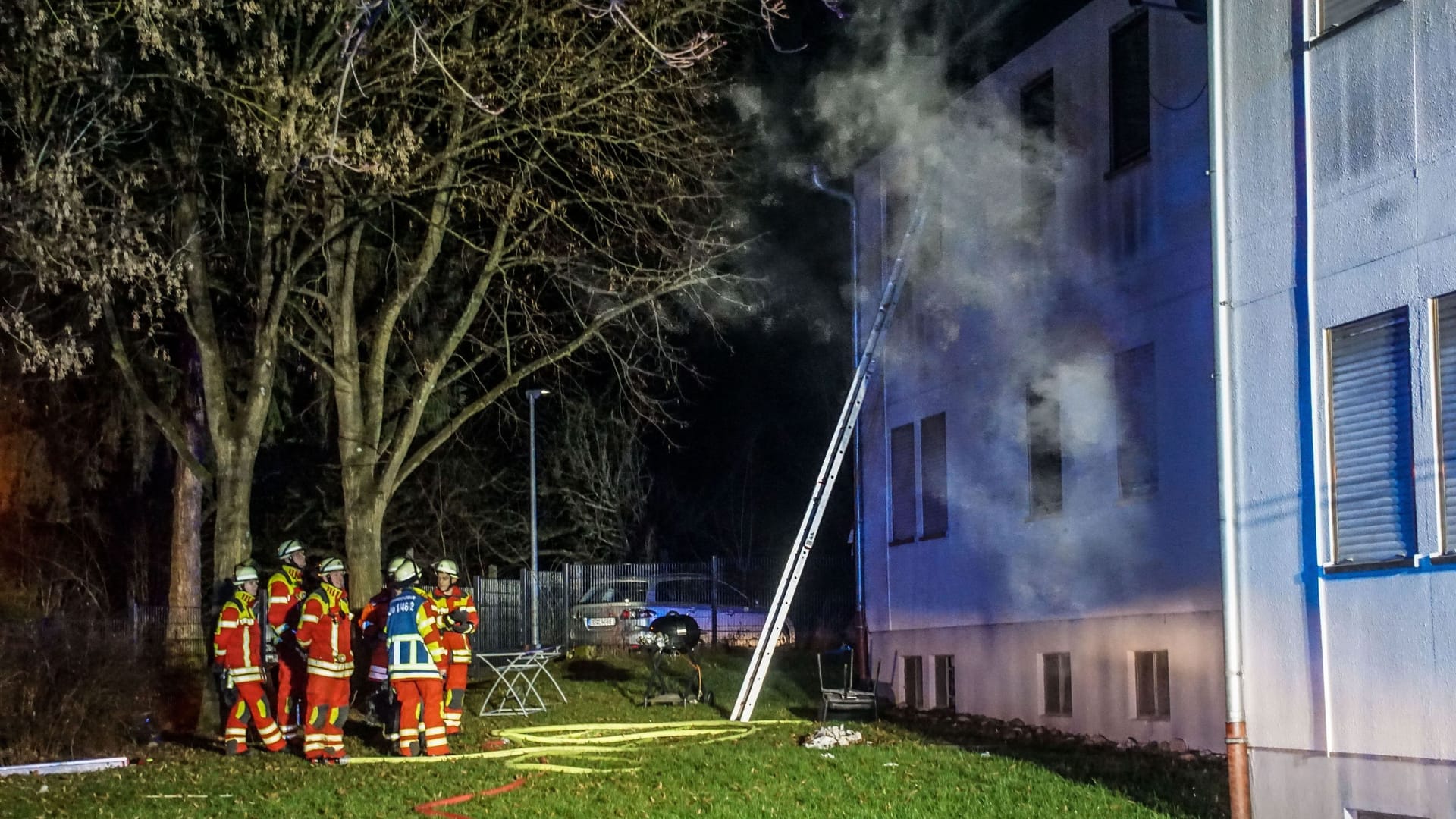 Feuerwehrleute stehen vor der Sozial- und Flüchtlingsunterkunft in Leonberg: 250.000 Euro Schaden sind durch den Brand entstanden.