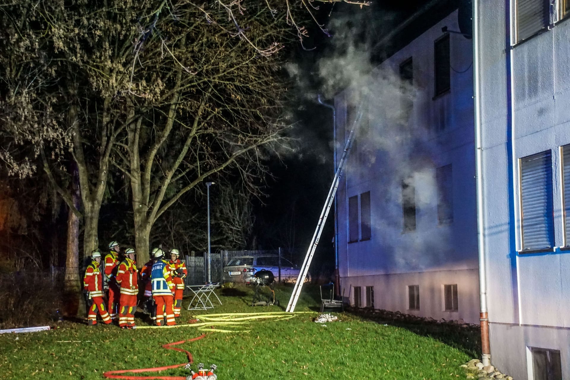 Feuerwehrleute stehen vor der Sozial- und Flüchtlingsunterkunft in Leonberg: 250.000 Euro Schaden sind durch den Brand entstanden.