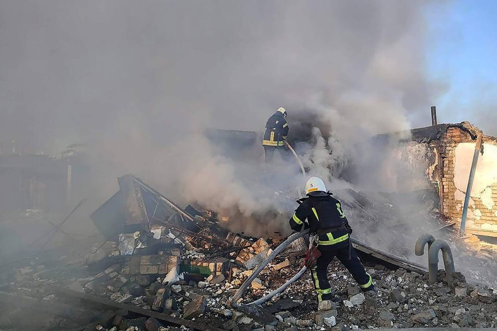 Feuerwehrleute löschen einen Brand in den Trümmer eines zersörten Wohnhauses in Mikolajew am Silvestertag. Die neue Welle russischer Angriffe traf auch Kiew, wobei eine Person ums Leben kam.