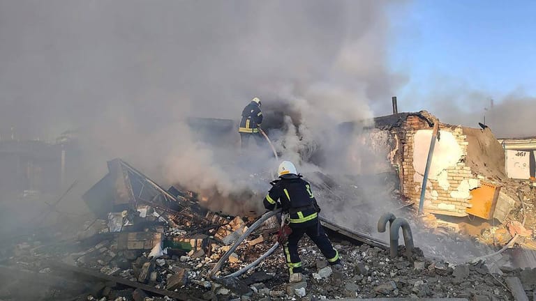 Feuerwehrleute löschen einen Brand in den Trümmer eines zersörten Wohnhauses in Mikolajew am Silvestertag. Die neue Welle russischer Angriffe traf auch Kiew, wobei eine Person ums Leben kam.