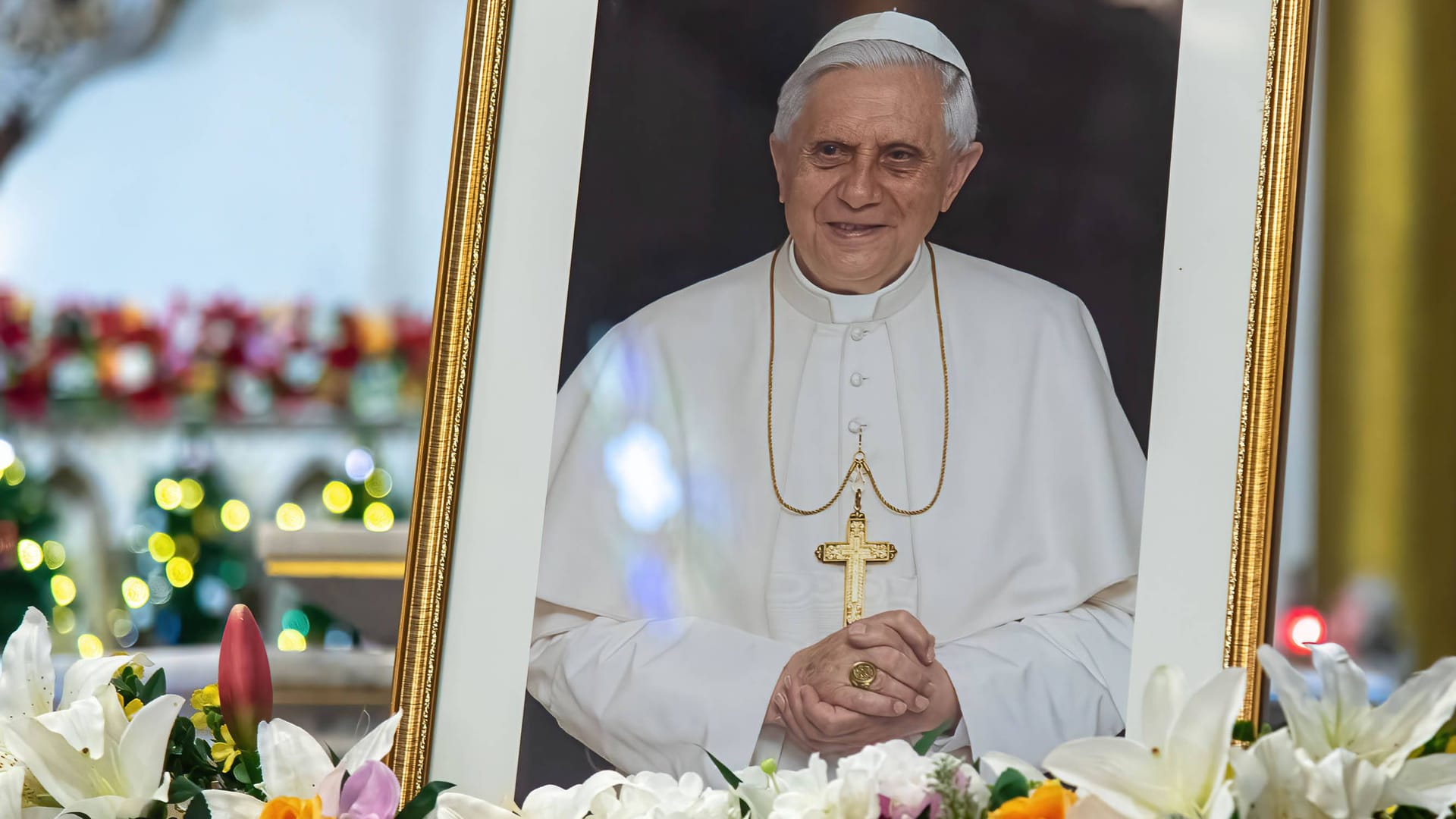 Ein Bild des verstorbenen Benedikt XIV. in einer Kirche: Zur Trauerfeier am Donnerstag haben sich zahlreiche namhafte Politikerinnen und Politiker angekündigt.