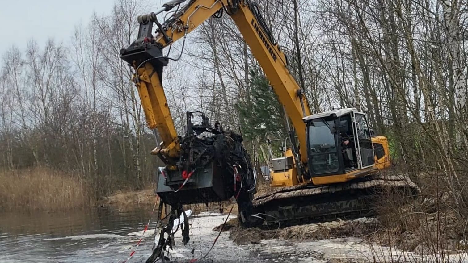 Ein Bagger holt die Überreste des Autowracks aus dem See bei Lunestedt. Ein Bagger holt die Überreste des Autowracks aus dem See bei Lunestedt.