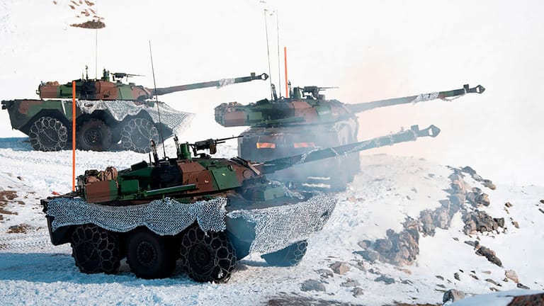 Drei Panzer mit Kanonen im Schnee.