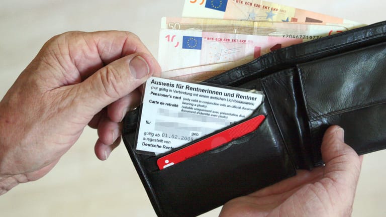 Rentner öffnet sein Portemonnaie (Symbolbild): Wer im Alter mit seiner Rente nicht auskommt, kann Grundsicherung beantragen.