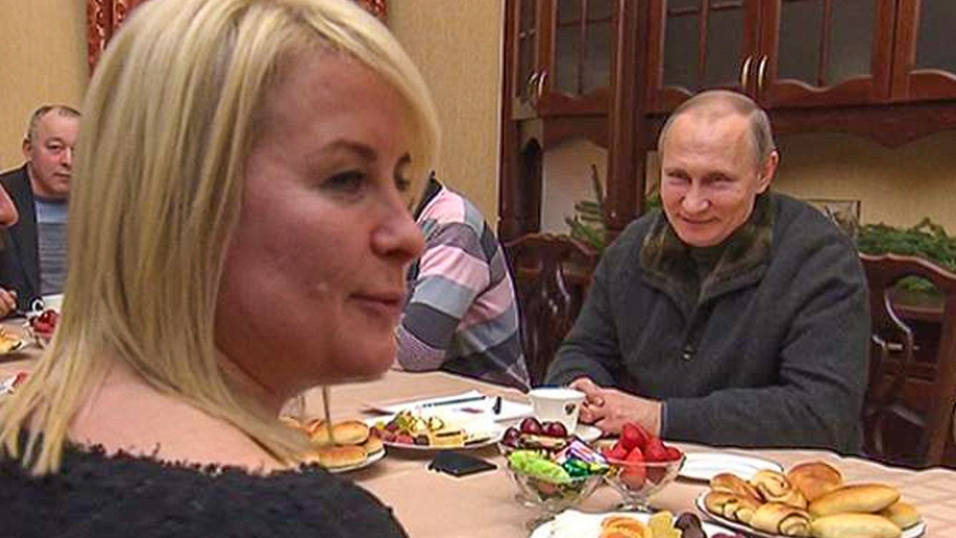 Eine blonde Frau sitzt gegenüber Putin