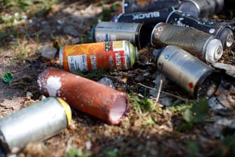 Verschiedene Spraydosen auf dem Boden (Symbolfoto): Die Graffitis entstanden wahrscheinlich am Wochenende.