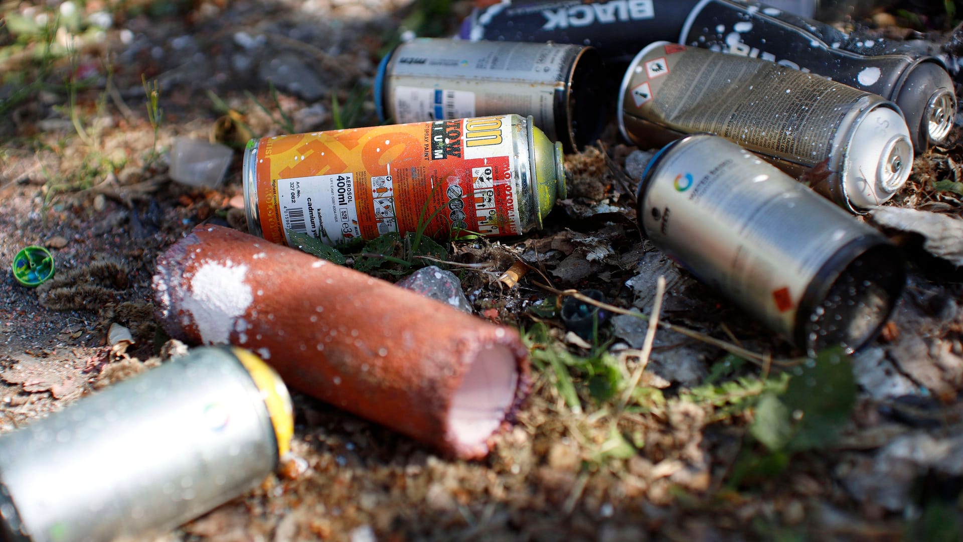 Verschiedene Spraydosen auf dem Boden (Symbolfoto): Die Graffitis entstanden wahrscheinlich am Wochenende.