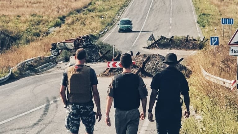 Schmid mit Helfern vor Panzersperren in der Ukraine.