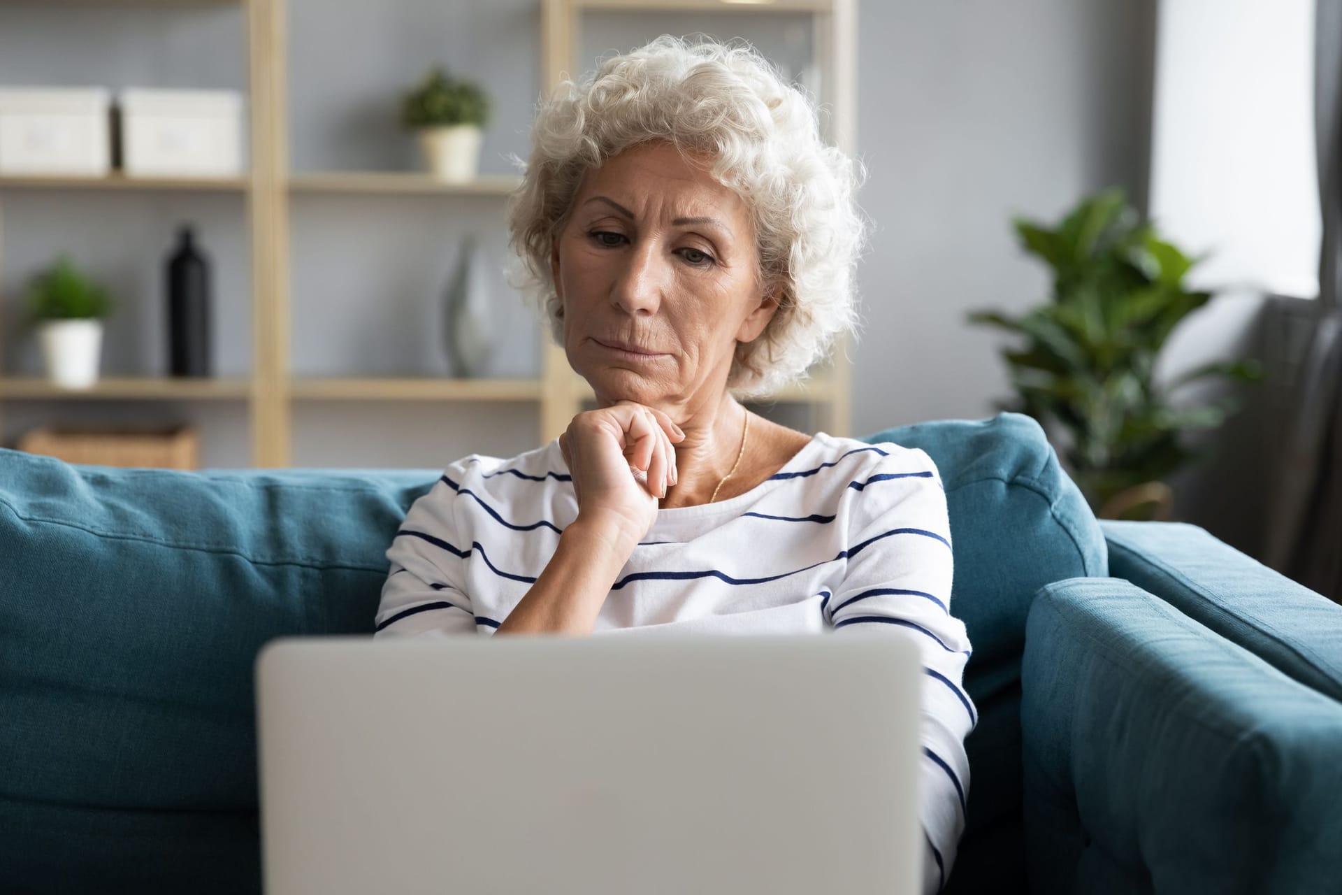 Ältere Frau schaut kritisch auf ihr Laptop (Symbolbild): Bei der Rente mit 63 gehen viele von einer falschen Annahme aus.