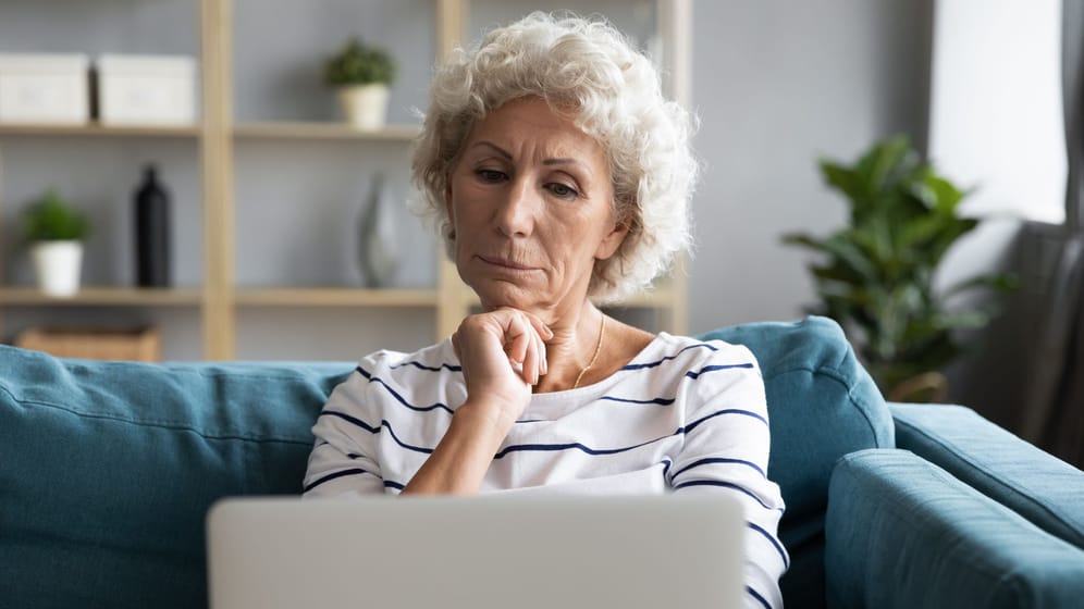 Ältere Frau schaut kritisch auf ihr Laptop (Symbolbild): Bei der Rente mit 63 gehen viele von einer falschen Annahme aus.