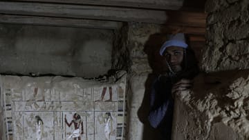 Ein ägyptischer Arbeiter steht in einem Grab.