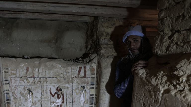 Ein ägyptischer Arbeiter steht im Inneren eines Grabes.