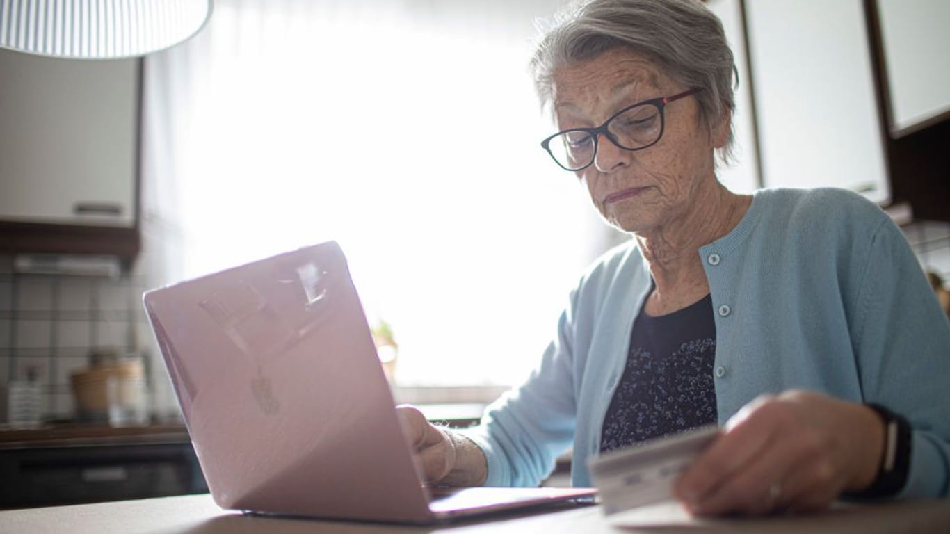 Eine Rentnerin prüft ihren Kontostand (Symbolbild): Witwenrente wird mit anderen Einkommen verrechnet.