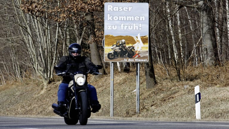 Motorradfahrer und Warnschild (Symbolfoto): Der junge Mann hatte seinen Führerschein noch nicht mal ein halbes Jahr.