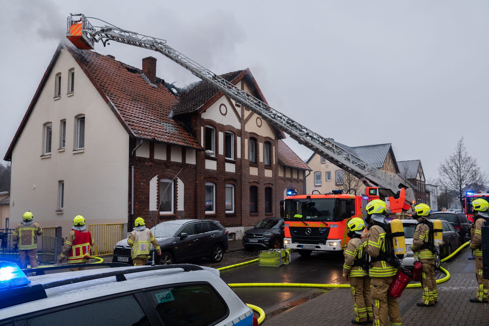 Einsatzkräfte der Feuerwehr Hannover löschen einen Brand eines Doppelhauses: Im Stadtteil Stöcken war nach Feuerwehrangaben im Obergeschoss ein Feuer ausgebrochen.