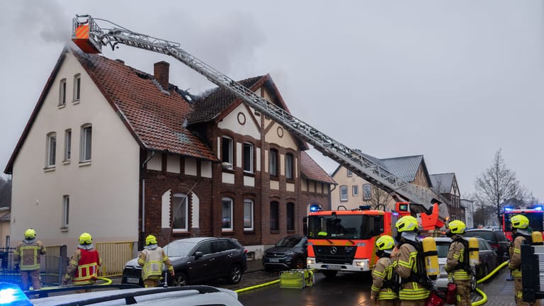 Einsatzkräfte der Feuerwehr Hannover löschen einen Brand eines Doppelhauses: Im Stadtteil Stöcken war nach Feuerwehrangaben im Obergeschoss ein Feuer ausgebrochen.