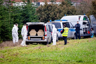 Mitarbeiter der Spurensicherung der Polizei stehen an einem Leichenwagen (Archivbild): Hier wurde die Leiche eines 14-Jährigen durch einen Gleichaltrigen abgelegt.