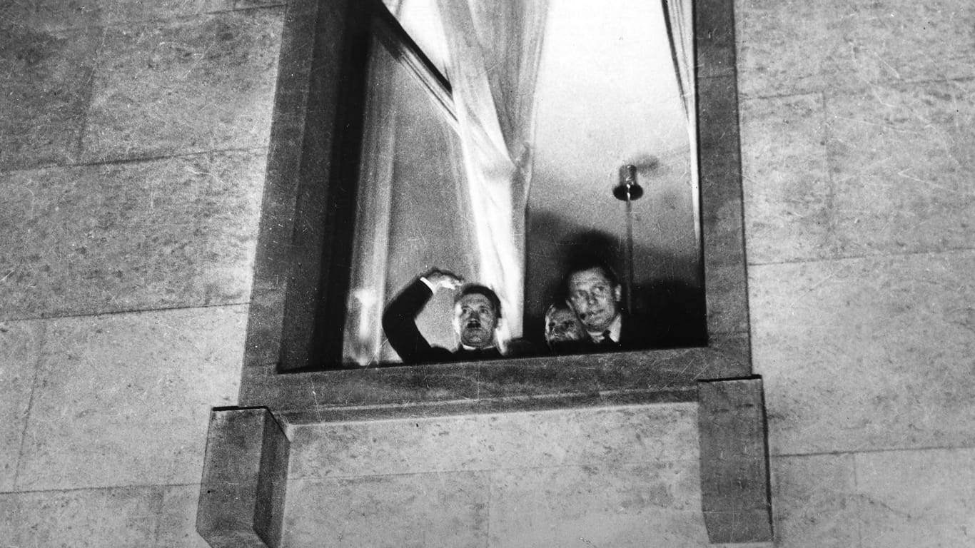 30. Januar 1933: Hitler (l. )grüßt aus einem Fenster nach der Ernennung zum Reichskanzler.