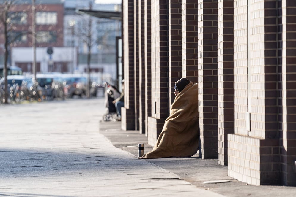 Ein Obdachloser sitzt an einem Bahnhof (Symbolfoto): Rettungssanitäter behandelten die Verletzungen des Mannes.