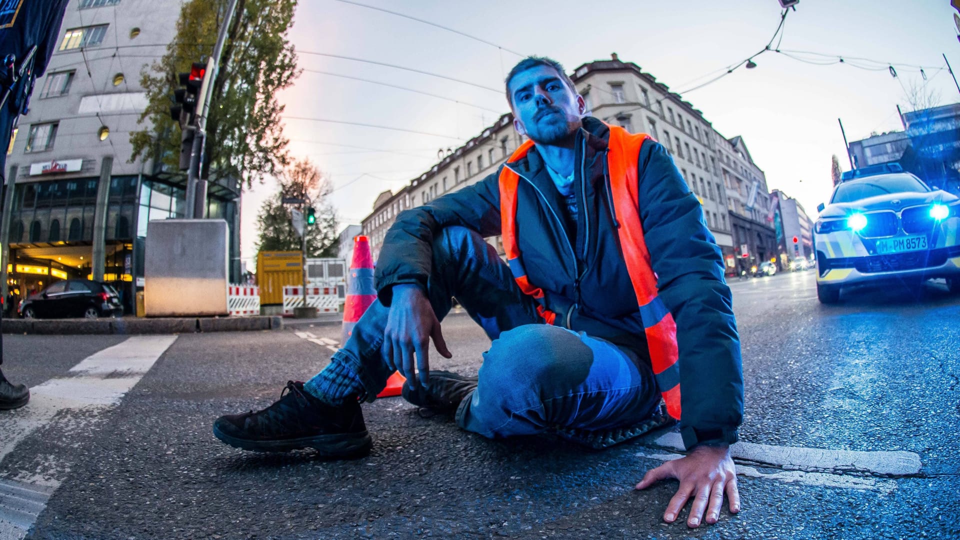 Mit bloßer Haut auf dem Asphalt festgeklebt - ein Aktivist der "Letzten Generation" protestiert in München: Ihre Methoden mag Habeck nicht gut finden, ihre Verzweifelung kann er nachvollziehen.