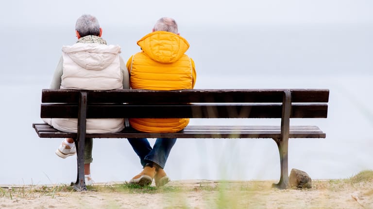 Rentnerpaar sitzt auf einer Bank (Symbolbild): Die Rente mit 63 wird stärker angenommen, als bei ihrer Einführung erwartet.
