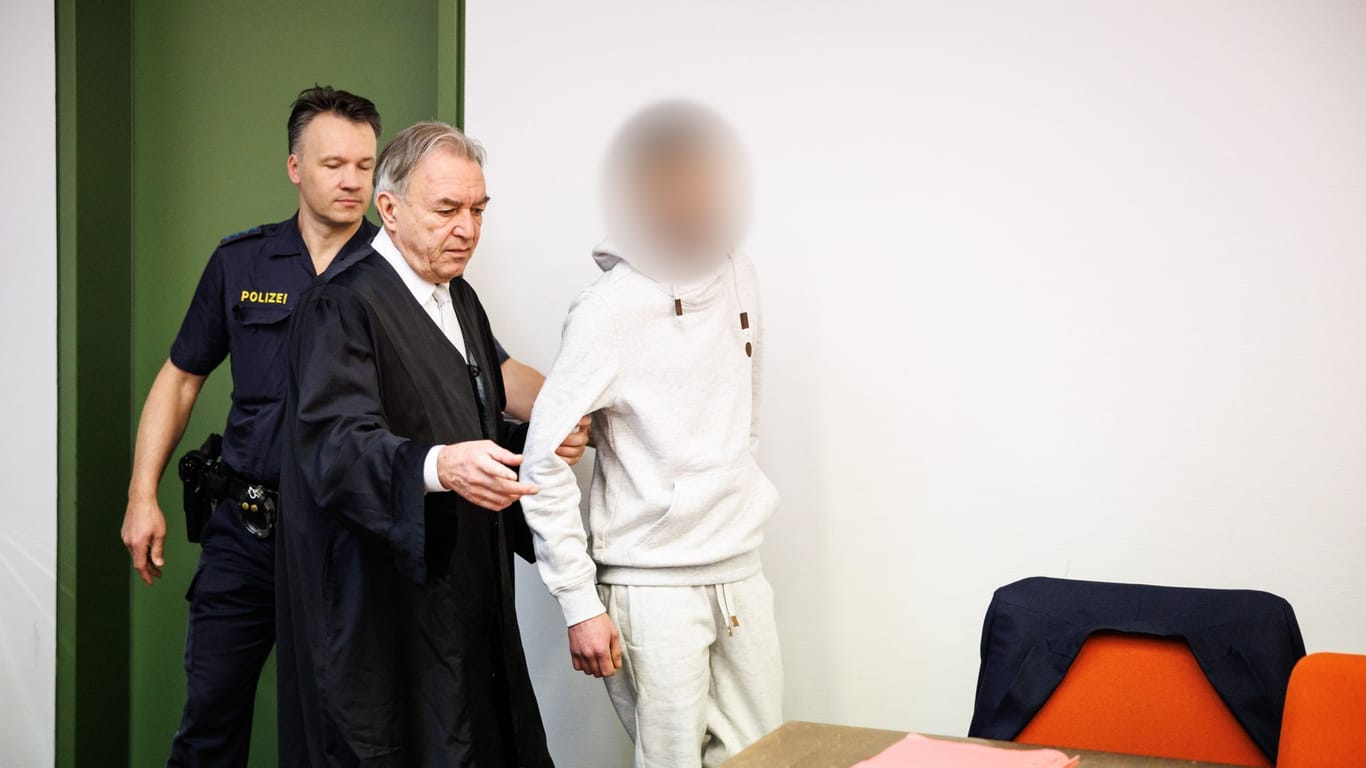 Ein wegen Totschlags angeklagter Mann (r) wird zu Prozessbeginn in einen Gerichtssaal vom Landgericht in München geführt.