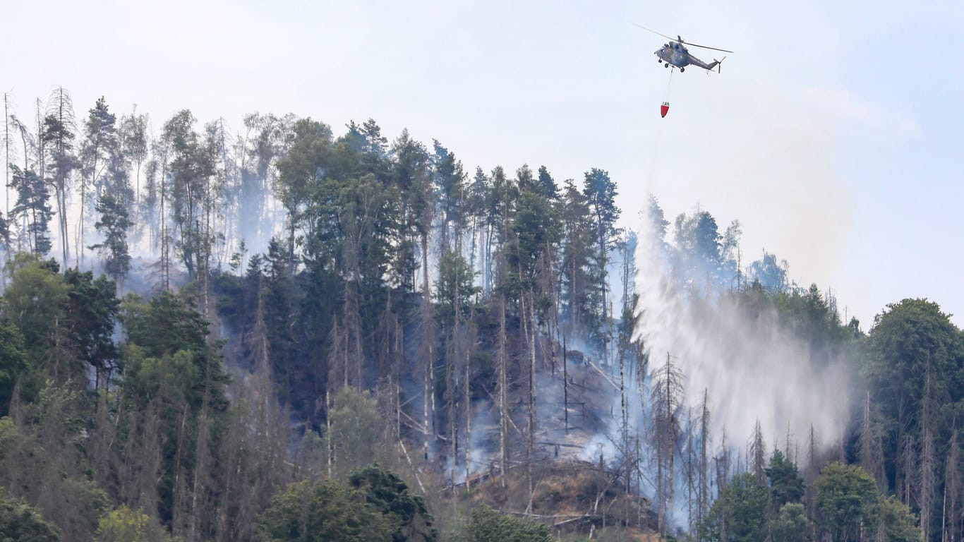 Ein Hubschrauber versucht im Sommer 2022 einen Waldbrand in der Sächsischen Schweiz zu löschen (Archivbild):