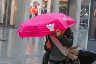 Eine Frau mit einem auffälligen Regenschirm in Hannovers City (Archivbild): Im Norden ist mit Sturmböen zu rechnen.