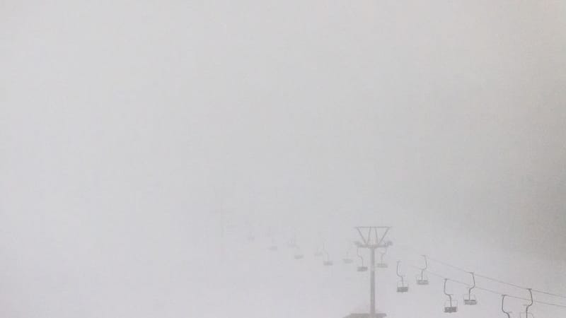 Liftsessel und Liftmasten nahe der Talstation der Feldbergbahn im Nebel.