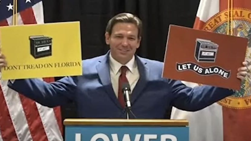 Floridas republikanischer Gouverneur Ron DeSantis hält Plakate mit Gasherden hoch: "Ihr nehmt uns unsere Gasherde nicht weg!"