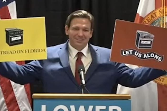 Floridas republikanischer Gouverneur Ron DeSantis hält Plakate mit Gasherden hoch: "Ihr nehmt uns unsere Gasherde nicht weg!"