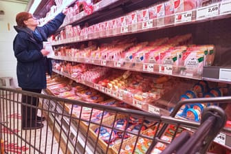 Es wird teurer: Frau im Supermarkt vor einem Regal mit Wurstwaren