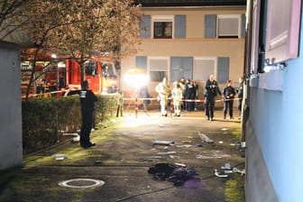 Einsatzkräfte von Polizei und Feuerwehr stehen in einem Wohngebiet in Hockenheim.