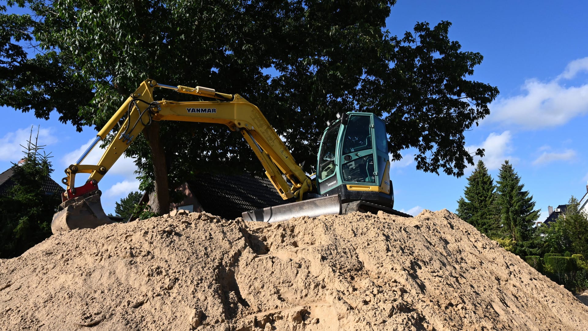 Ein Bagger auf einem Erdhaufen (Archivbild): Unter einem solchen Bagger wurde der Mann eingeklemmt. Ein Bagger auf einem Erdhaufen (Archivbild): Unter einem solchen Bagger wurde der Mann eingeklemmt.